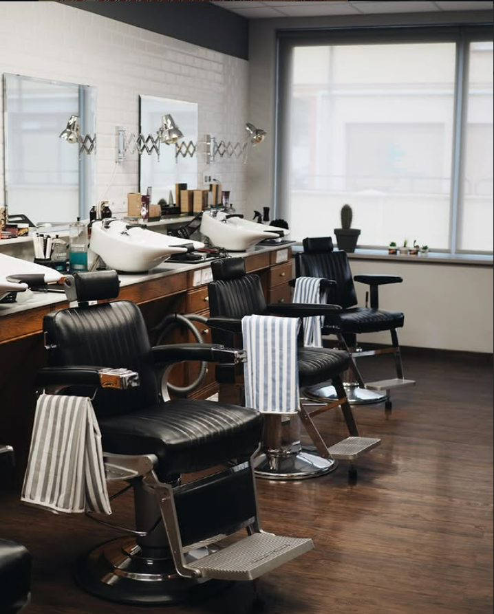 Interior de Barbería Tony en Navia, con sillas de barbero y espejos profesionales